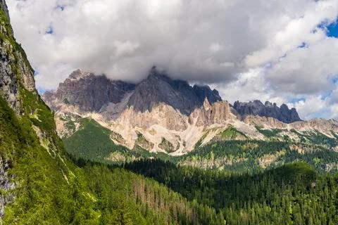 Thick cloud rests on rugged peaks of Dolomites, creating dramatic and sceni.. Stock Photos