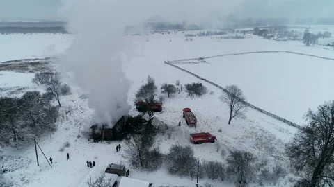 A thick cloud of smoke rises from the blazing fire of a house in the village Stock Footage 100348431