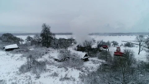 A thick cloud of smoke rises from the blazing fire of a house in the village Stock Footage 100348585