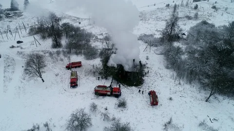 A thick cloud of smoke rises from the blazing fire of a house in the village Stock Footage 100349008