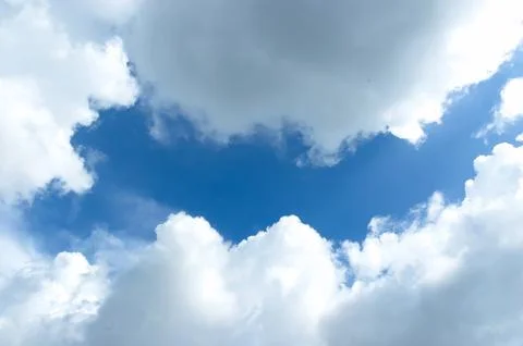 Thick clouds behind the hot sun. Beautiful white clouds in the bright blue .. Stock Photos