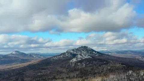 Thick clouds float over the snowy mountains and pine forest Video stock 126230370