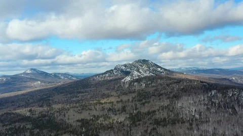 Thick clouds float over the snowy mountains and pine forest Stock Footage 126236003