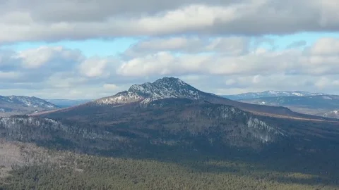 Thick clouds float over the snowy mountains and pine forest Video stock 126255774