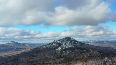 Thick clouds float over the snowy mountains and pine forest Video stock 126255780
