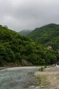 Thick clouds over the mountains, a river between the mountains, Georgia Stock Photos
