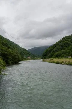 Thick clouds over the mountains a river between the mountains Stock Photos