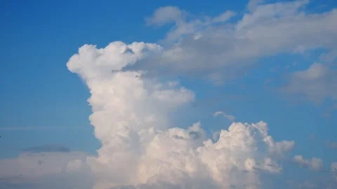 Thick clouds rise and change shape against a blue sky during the afternoon hours Stock Footage 343764623
