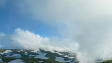 Thick clouds rolling in and covering the mountain summit Video stock 336099654