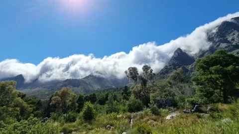 Thick Clouds Rolling In Over The Mountains On A Sunny Day Stock Footage 166944994