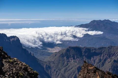 Thick clouds in the valley. Panorama from the top of the mountain. Stock Photos