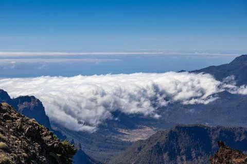 Thick clouds in the valley. Panorama from the top of the mountain. Stock Photos