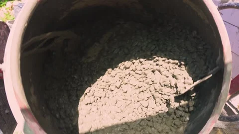 Thick concrete mortar flows down from the concrete mixer close-up in slow motion Stock Footage 278351592
