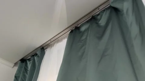 Thick curtains closing over window in apartment interior, blocking daylight, Stock Footage 336979007