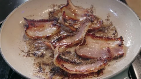 Thick cut bacon frying in a hot pan Видео 340237460