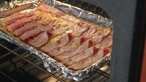 Thick-Cut Bacon Sizzling and Rendering on a Baking Sheet in the Oven Stock Footage 318275367