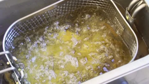 Thick cut chips being dunked into deep fat fryer Stock Footage 151972687