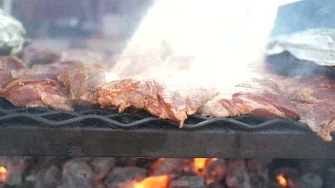 Thick cut pieces of Tri Tip meat cooking on BBQ with smoke and sun rays slow mo Vídeos de archivo 132823832