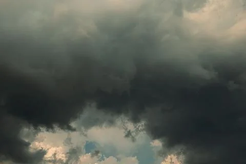 Thick dark clouds fill sky, showing signs of approaching storm. mix of gray a Stock Photos