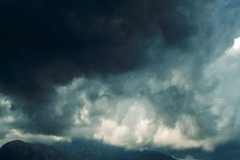 Thick dark clouds fill sky, showing signs of approaching storm. mix of gray a Stock Photos