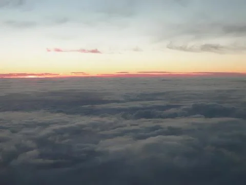 Thick dark clouds under the wing of the plane, beautiful sunset Stock Photos