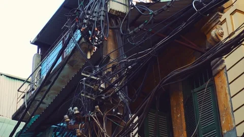 Thick electric cables crisscrossing aged buildings in Hanoi city streets Stock-Footage 340030038