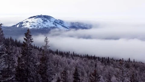 Thick fog flows around the snow-capped mountain time lapse Stock Footage 81363904