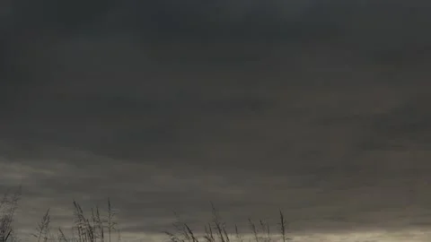 Thick gray clouds advancing through a cloudy rainy sky time lapse Stock Footage 222003093