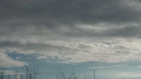 Thick gray clouds advancing through a cloudy rainy sky time lapse Stock Footage 222003095