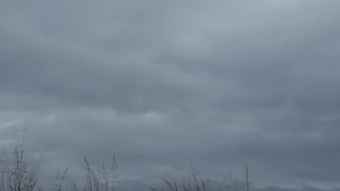 Thick gray clouds advancing through a cloudy rainy sky time lapse Stock Footage 222003139
