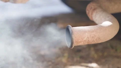 Thick gray smoke comes from the rusty exhaust pipe of an old diesel car close-up Stock Footage 190943636