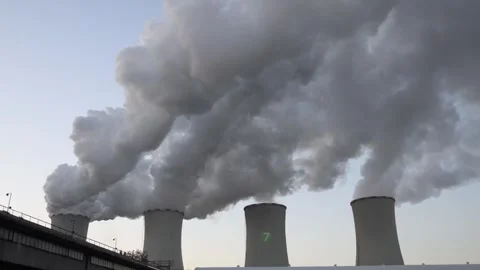 Thick gray steam rises heavily from large cooling towers filling the pale  Stock Footage 321650805