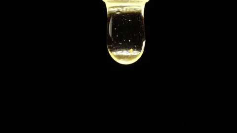 Thick honey drop dripping on black background. Macro shot. Stock Footage 83502322