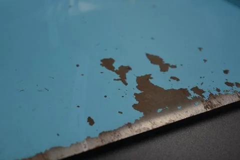 A thick layer of painted metal from which blue paint has peeled off. Foto stock