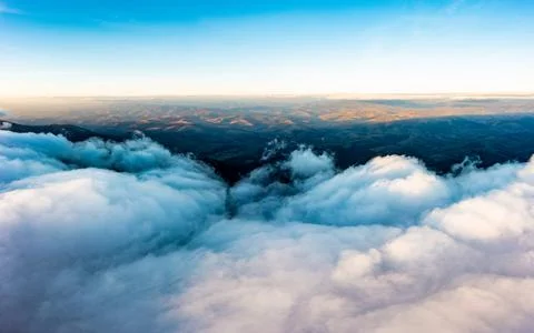 Thick layer of white clouds above mountains at sunrise Stock Photos
