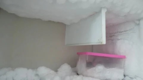 A thick layer of white ice and frost builds up inside the refrigerator Stockbeeldmateriaal 333443249