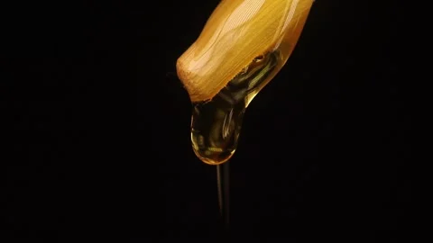 Thick liquid drop of honey falling over black background. Healthy Food Concept Stock Footage 246126257