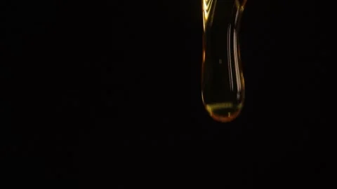 Thick liquid drop of honey falling over black background. Healthy Food Concept Stock Footage 246127553