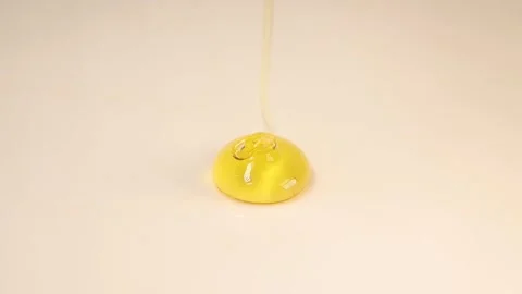 Thick liquid of honey falling over a white background. Healthy Food Concept Video stock 246137088