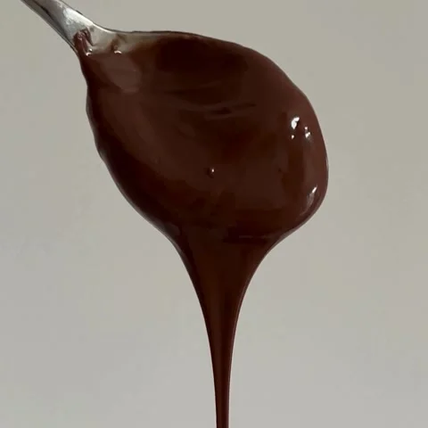 Thick Melted Chocolate or Hazelnut Cream Dripping from Silver Spoon Isolated Stock Footage 322523771
