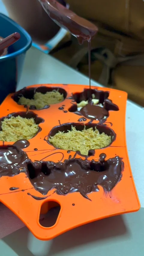 Thick melted chocolate slowly drips from spoon onto crispy kunafa filling in Video stock 343478708