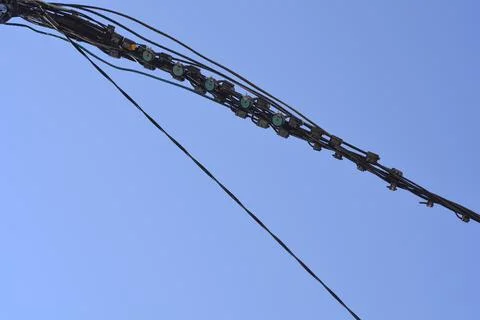 Thick overhead power line bundle against a clear blue sky Stock Photos