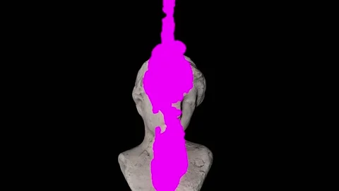 Thick pink paint is squeezed onto the head of the ancient statue and spreads. Stock Footage 156043657
