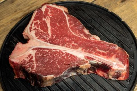 Thick Raw T-Bone Steak with Seasoning and Rosemary Stock Photos