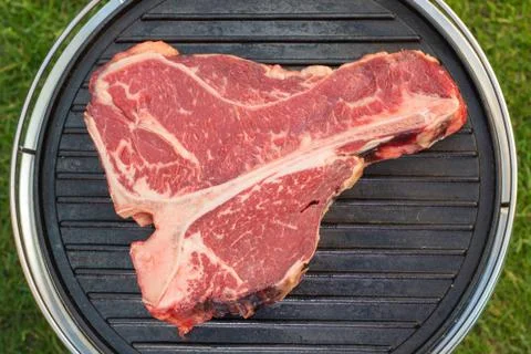 Thick Raw T-Bone Steak with Seasoning and Rosemary Stock Photos