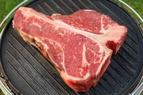 Thick Raw T-Bone Steak with Seasoning and Rosemary Stock Photos