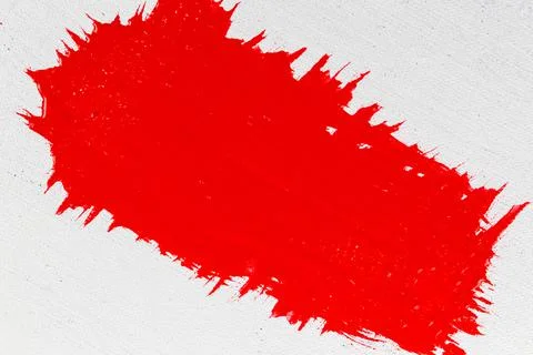 Thick red acrylic paint applied in an uneven patch on a flat surface Stock Photos