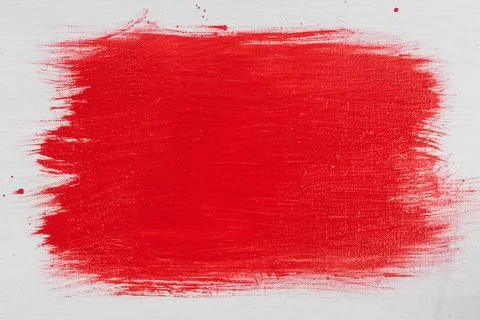 Thick red acrylic paint applied in an uneven patch on a flat surface Stock Photos