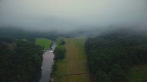 Thick sheet of foggy clouds over green landscape and river Stock Footage 81535659