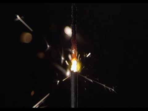 A thick short sparkler burning, Sparks are flying, camera moving along, phase 4 Stock Footage 74310165